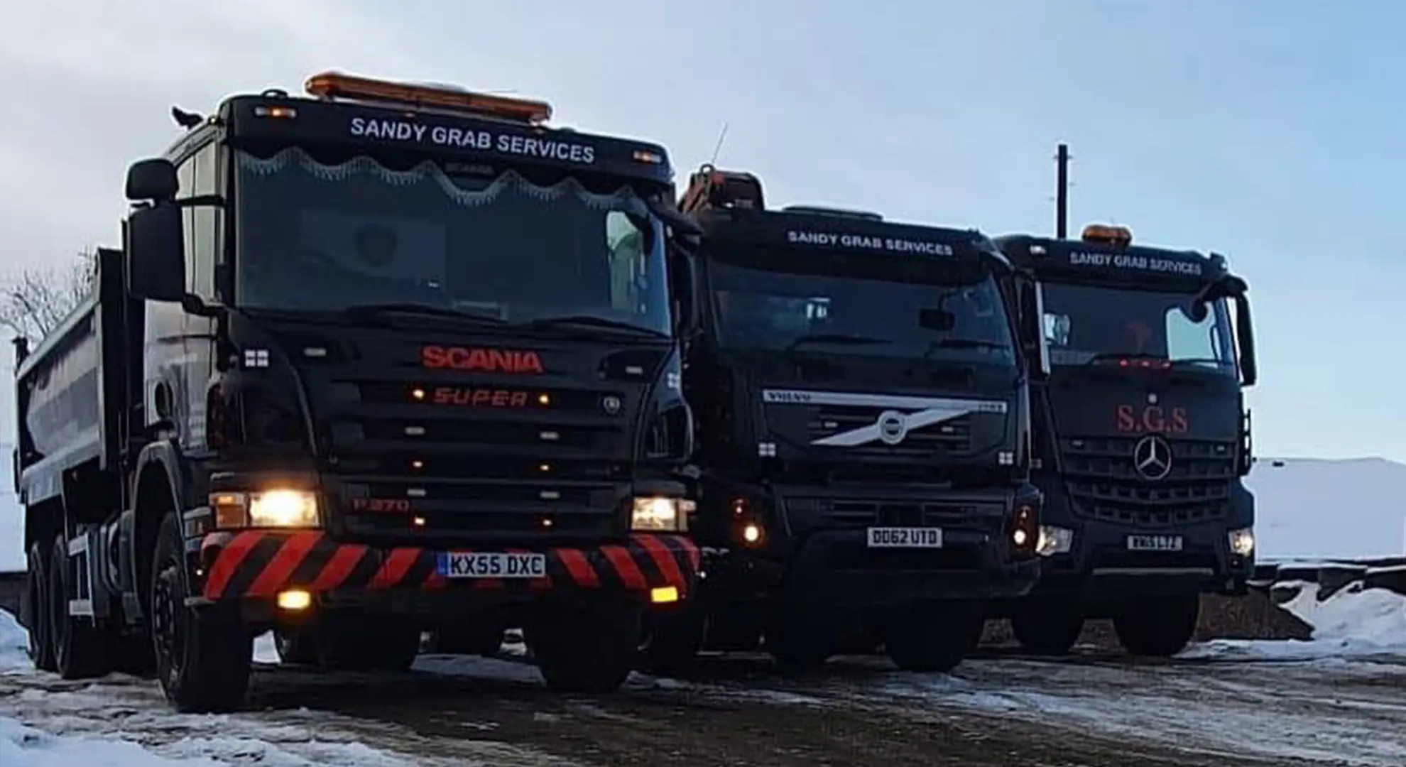 Three Sandy Grab Services tipper lorries lined up in the yard